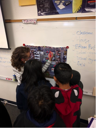 A group of students standing in front of a whiteboard
