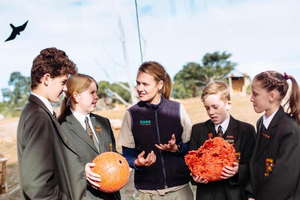 Four students and a teacher standing outside