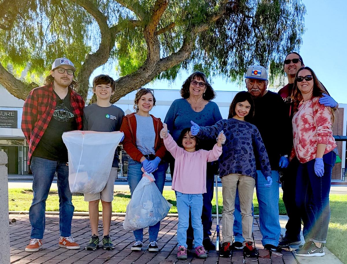 Members of the community smile as they celebrate a successful trash clean up day.