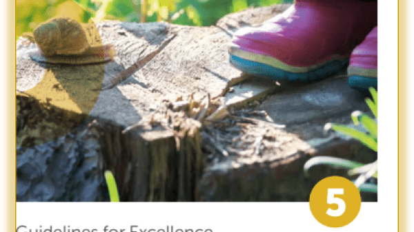 Close-up of pink rain boots standing near a snail