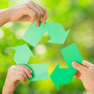 Three hands holding sections of the recycle symbol.