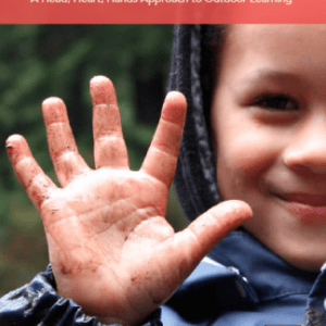 child holding up muddy hand