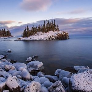 Snow covered island on Lake Superior during sunset.