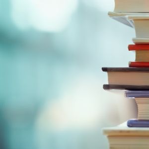Book stack in the library room and blurred bookshelf