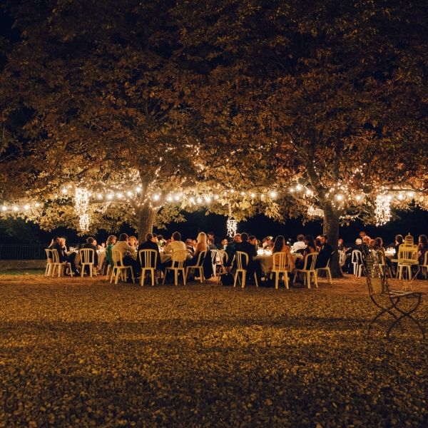 Nighttime outdoor wedding reception with lights