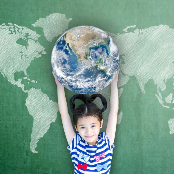 Girl holding the Earth over her head smiling