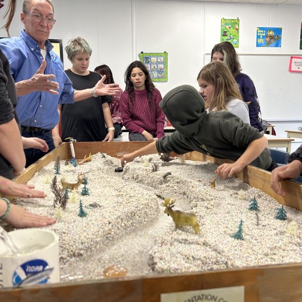 Max Tritt, NOAA educator and fisheries biologist, using the stream-flow table with students.